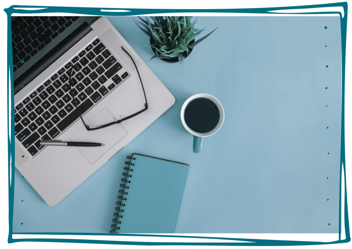 Laptop on desk with notebook and coffee